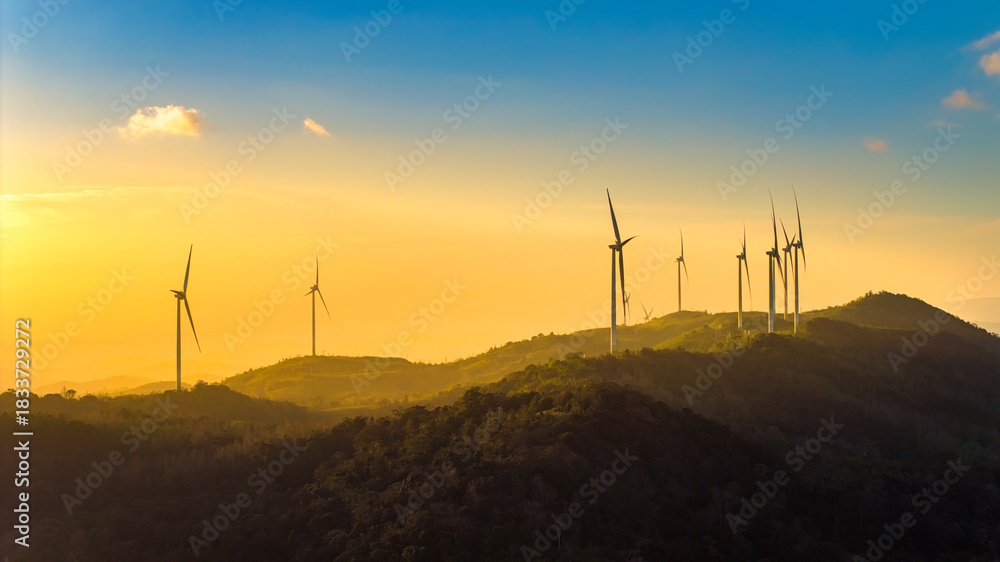 Fototapeta premium Aerial view of windmill turbines park generating green energy electric.Solar panels park and wind turbines at sunset.Green energy reduce carbon emissions and makes earth cleaner, Quang Tri, Vietnam
