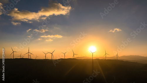 Panoramic view of wind farm or wind park, with high wind turbines for generat...