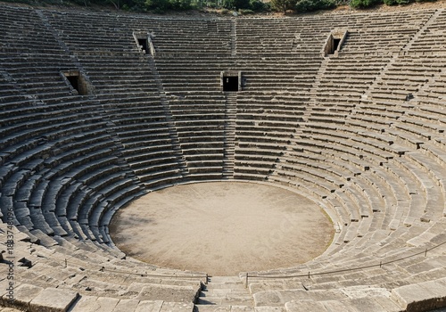 Vast historical open-air arena featuring impressive curved stone tiers, perfect for large gatherings and cultural events ,monumental ,circular ,engineering