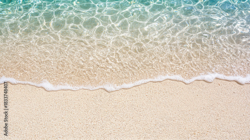 Fototapeta Naklejka Na Ścianę i Meble -  Shallow clear water sandy beach gentle wave shoreline sea foam turquoise water summer coastal