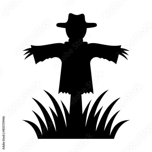 Black silhouette of a scarecrow standing in tall grass