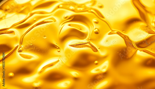 Abstract golden liquid texture with organic flowing patterns and light reflections