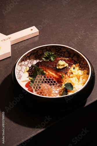 Culinary expert displays crispy mackerel served over rice with decorations