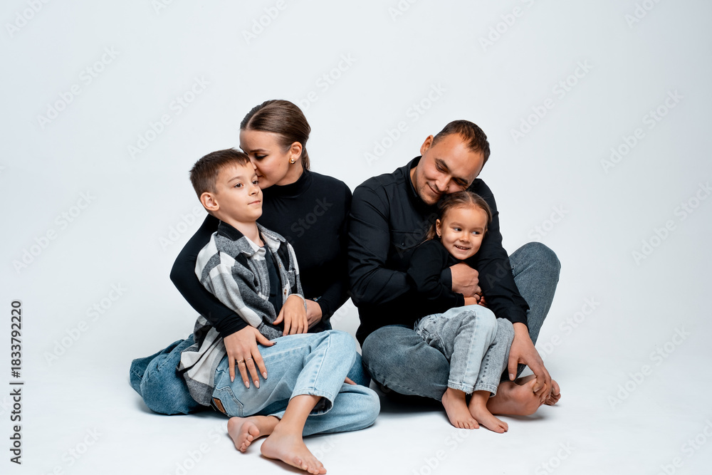 Fototapeta premium family with two children, mom, dad, son, and daughter on a white isolated background, hugging, a young happy family