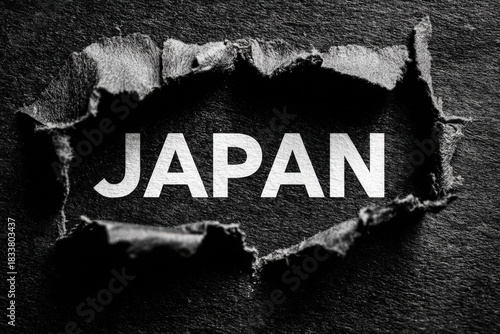 Torn paper revealing the word JAPAN, showcasing a dramatic contrast against a dark background, symbolizing discovery and cultural exploration in visual storytelling