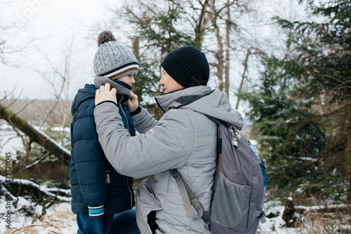 Wallpaper Mural Father adjusting son's scarf during winter forest hike Torontodigital.ca