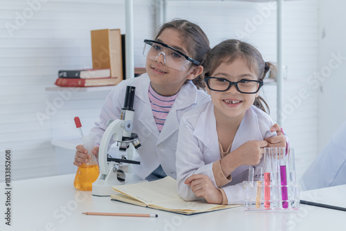 Group of sibling students kids lab coat uniform studying science class in laboratory, Iranian pupils girls scientists having fun at school in lab with microscope and test tube, kid scientist concept