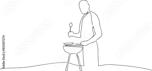 Person grilling food on a charcoal barbecue cooking