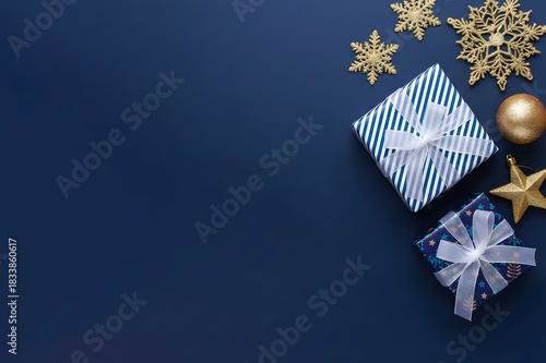 A flat lay of Merry Christmas and Happy Holidays greeting card, frame and banner. New Year. Noel. k gold Christmas ornaments and gifts, presents on blue background top view. Winter xmas holiday theme.