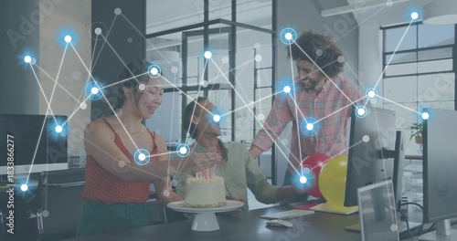 Celebrating 3 coworkers in office attire reaching toward cake at open office with digital overlay