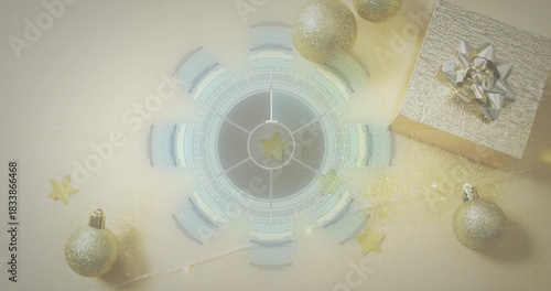 Displaying central circular graphic glowing on pale beige table with silver gift and gold baubles