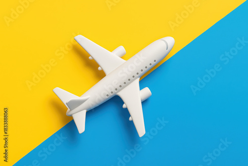 White toy airplane for travel on blue and yellow background. concept of hopeful support and flight for Ukraine