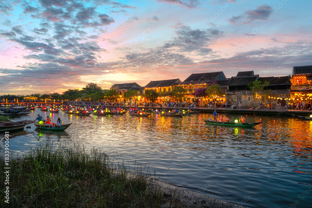 Fototapeta premium Hoi An, Vietnam at night and many tourists. Long-tail boats decorated with Vietnamese paper lanterns. A beautiful and important tourist attraction in Vietnam. Hoi An, Vietnam 