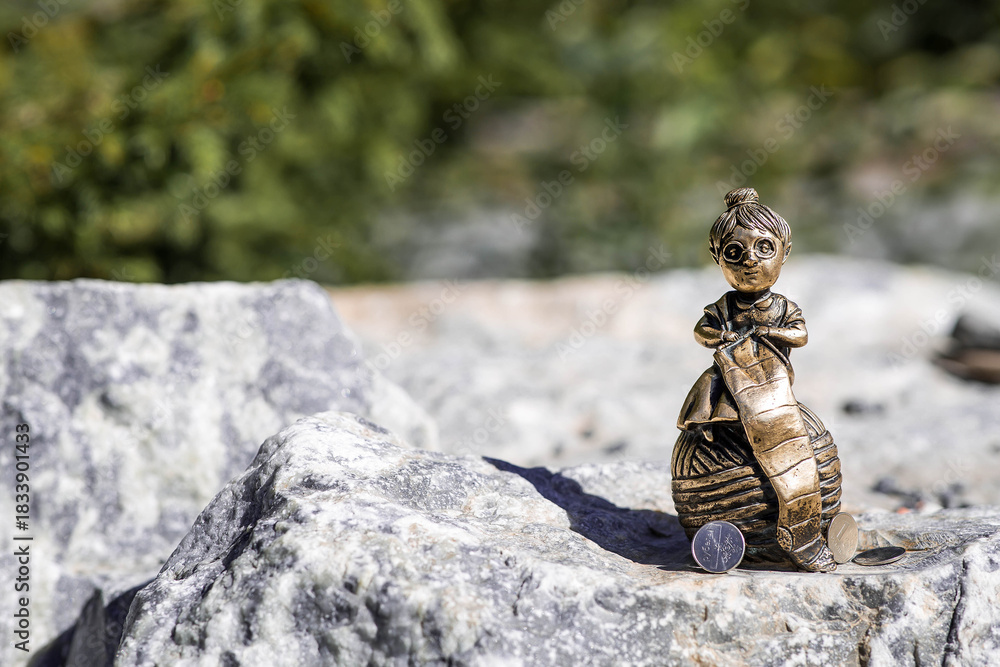 Obraz premium Ruskeala, Karelia, Russia - August 12, 2025: Close-up of a knitting grandmother. The keepers of the Ruskeala Mountain Park are the Marmorik family.