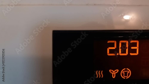 Digital display of electric dryer shows startup sounds and program selection in a laundry room setting