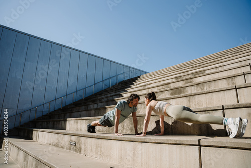 Canvastavla A man smiles and listens to the woman across from him as they stand on the stair