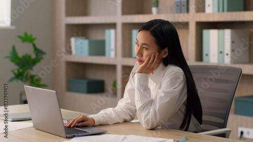 Brainstorming pensive Asian Japanese office worker employer business woman Chinese Korean female businesswoman entrepreneur thinking have idea pointing index finger thought work laptop desktop indoor