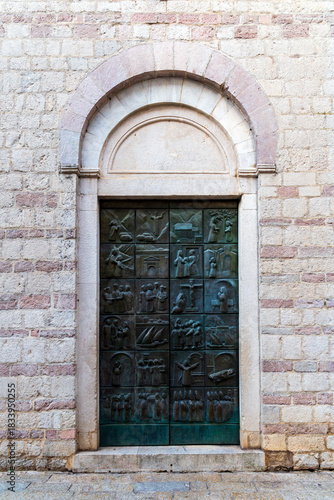 The bronze doors of the Church of St. Mary Collegiate or the church of St. Osanna depicting the saint's life, city of Kotor. Montenegro.