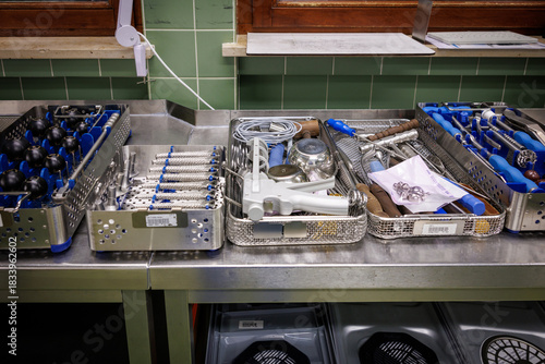 A row of organized surgical instrument trays prepared in a hospital sterilization department.