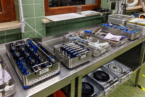 A row of organized surgical instrument trays prepared in a hospital sterilization department.