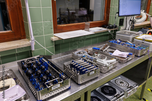 A row of organized surgical instrument trays prepared in a hospital sterilization department.