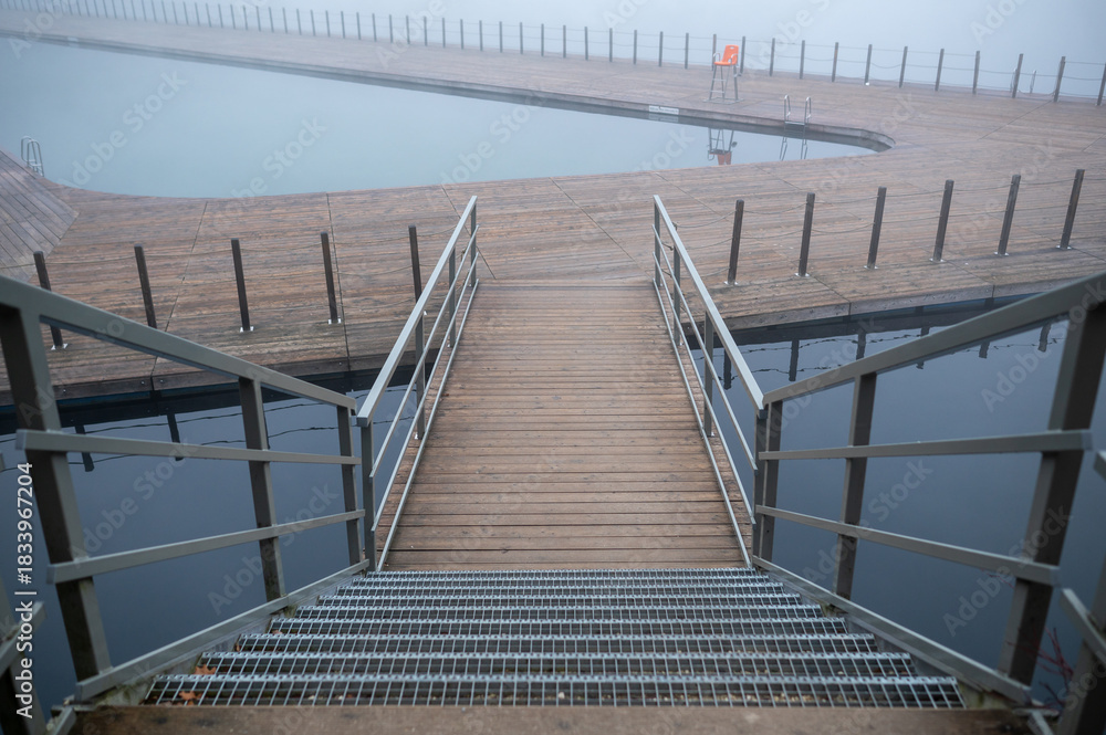 Fototapeta premium Foggy Pier with Metal Railings Over Water
