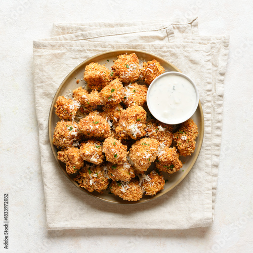 Crispy breaded oven baked cauliflower bites served with dipping sauce