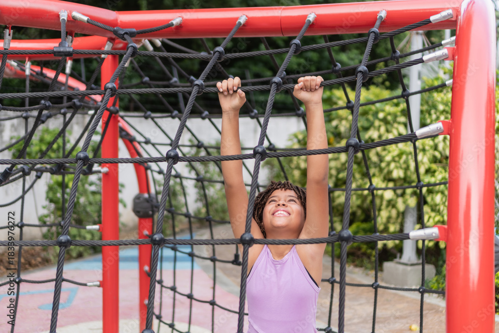 Fototapeta premium Happy child climbing playground rope structure outdoors