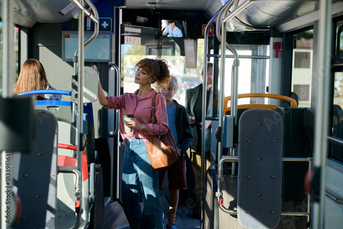 Woman traveling on public bus holding coffee cup