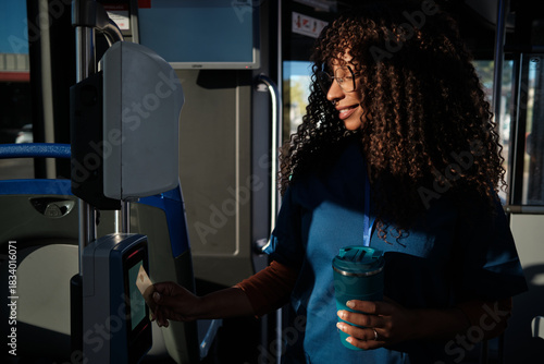 Fotografie Young woman paying bus fare using contactless card