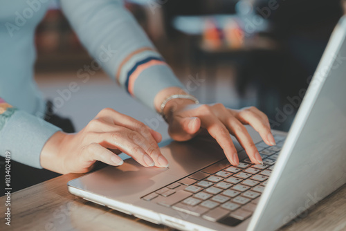 Female hands using laptop touchpad and keyboard.Business woman working on computer modern remote work at home,freelance lifestyle,digital communication concept in soft natural lighting environment
