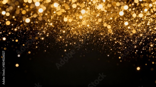 Golden glitter bokeh falling on dark background