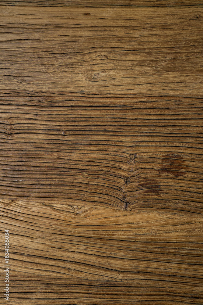Naklejka premium A close-up of a wooden surface with rich brown tones and natural grain patterns. Darker stains add character and suggest aging or usage.