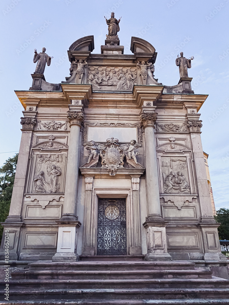 Obraz premium Architectural monument featuring intricate sculptures and detailed carvings, showcasing historical artistry and craftsmanship against a clear sky, symbolizing cultural heritage and history