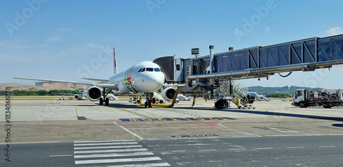 commercial airplane loading passengers with fingertips on the takeoff platform for a tourist trip