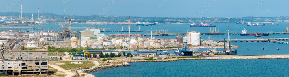 Obraz premium Aerial view of the petrochemical complex located on the coast overlooking the sea. Large oil refinery.