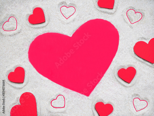 Creative sand texture with big heart on sand background for your messeges. And small wooden red hearts between drawing. Valentine's day, mother's, woman's day, honeymoon, vacation, summer.