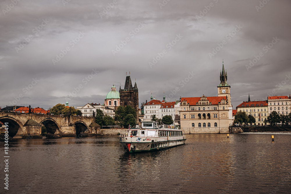 Fototapeta premium Historic Prague cityscape along the Vltava River with iconic Charles Bridge and architecture.