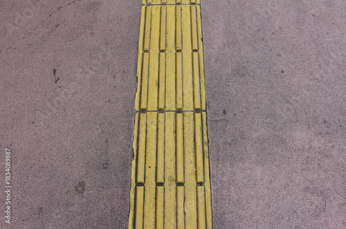 Wallpaper Mural Yellow blocks of tactile paving for blind handicap. Tactile pavement for the visually impaired close up background. Texture of pink asphalt road with Braille blocks in the street. Torontodigital.ca