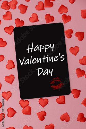 A black card with the text 'Happy Valentine's Day' surrounded by small red heart shapes on a pink background. Perfect for romantic themes.
