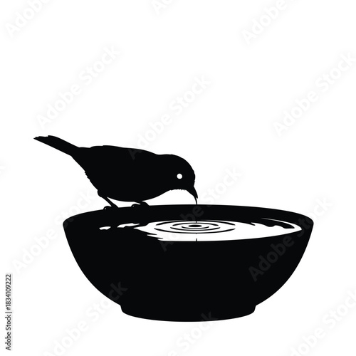 A small bird drinks water from a bowl silhouette