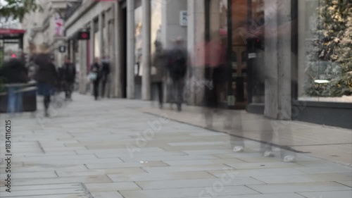 Timelapse of busy street of people in retail shop high street setting - London