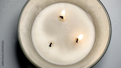 A man blows out a triple holiday candle