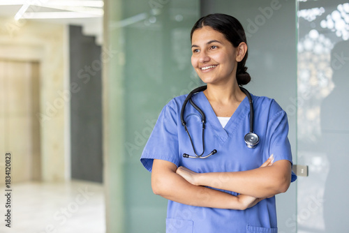Photos Female healthcare professional standing with arms crossed, smiling while looking