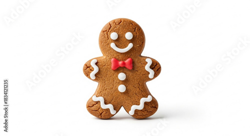 A cheerful gingerbread man cookie decorated with white icing for eyes a smile buttons and wavy lines on its arms and legs and a red bow tie isolated on a clean white background