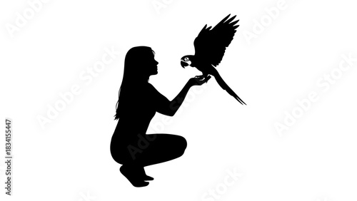 Silhouette of woman with parrot perched on hand in a white backdrop