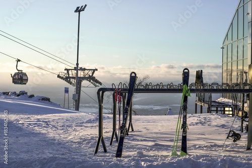 Skis and Snowboards at Sunset Over City Panorama at ski resort in winter