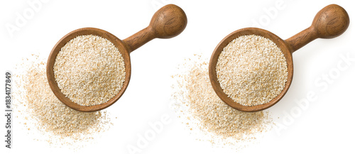 Uncooked oat bran in the wooden spoon, isolated on white background, top view.