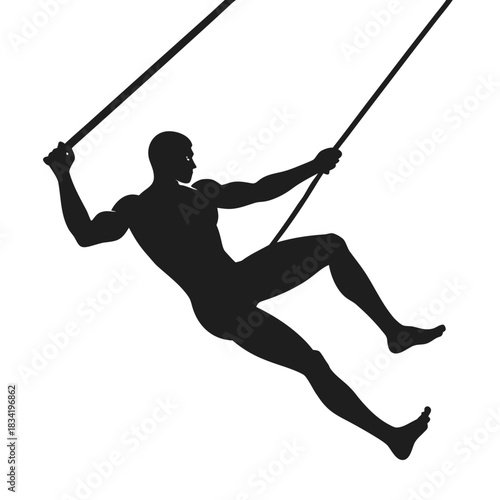 Silhouette of a male trapeze artist performing a dynamic acrobatic move on ropes