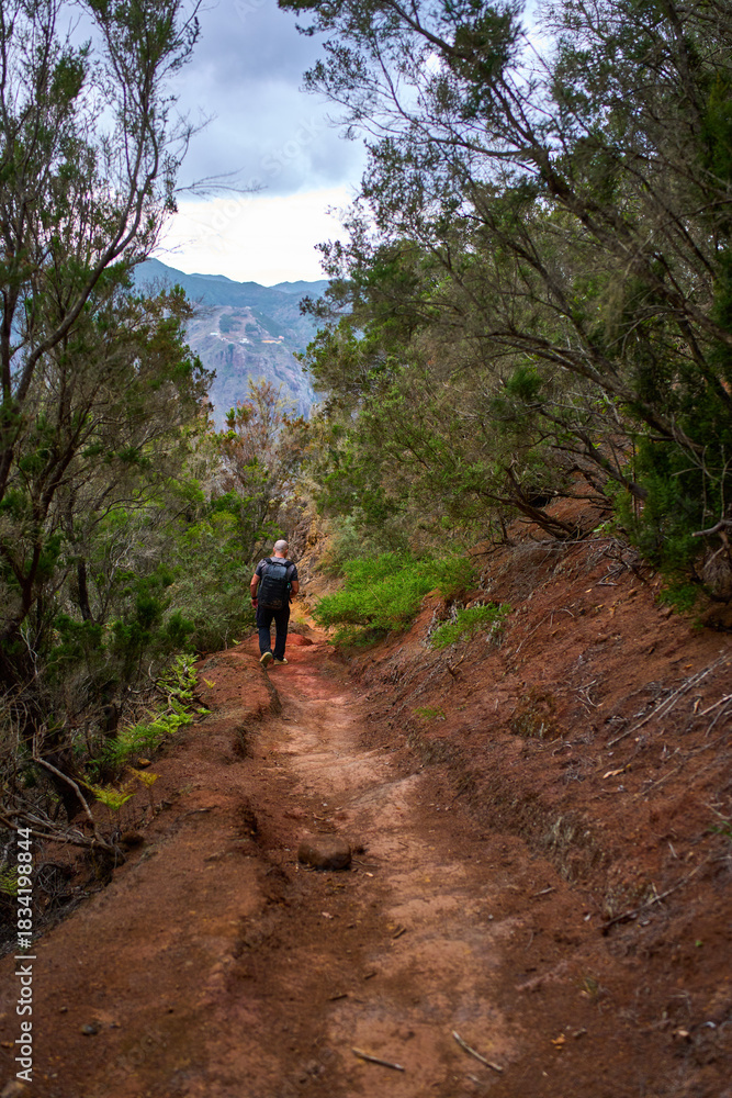 Fototapeta premium Man hiking downhill towards Afur village